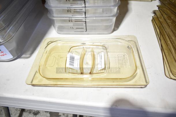 Lot of containers, drop-in bins, and lids, some with measurement markings, stacked on a table. Mixed condition.