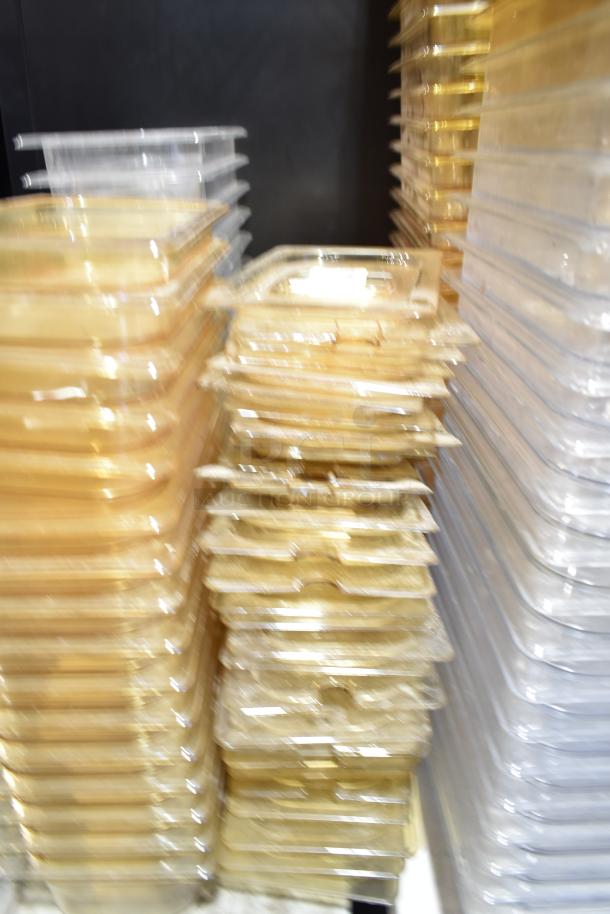 Lot of various plastic drop-in bins with lids, stacked high. Items appear new and well-maintained.