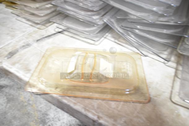 Lot of various items including clear plastic drop-in bins and lids. Items are stacked on a surface, showing moderate wear.