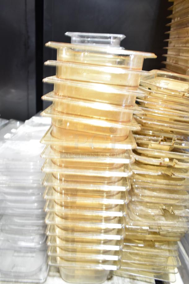 Stack of clear plastic drop-in bins with lids, used, various sizes, suitable for organizing and storage.