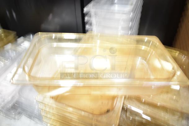 Lot of various plastic drop-in bins and lids in used condition, stacked together.