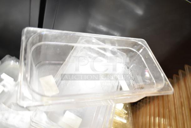 Lot of various items including clear plastic drop-in bins and lids, used condition, with visible labels and markings.