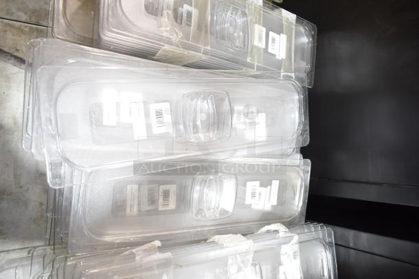 Lot of plastic drop-in bins with lids, stacked. Includes visible barcodes on each item. Ideal for storage solutions.