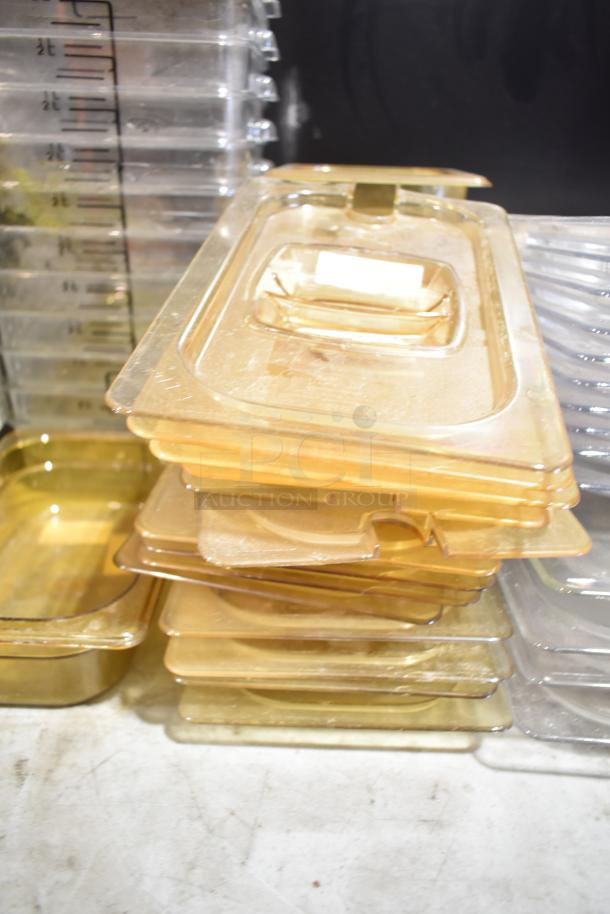 Lot of stackable plastic drop-in bins with lids, featuring clear and amber tones. Each bin has volume markings. Used condition.