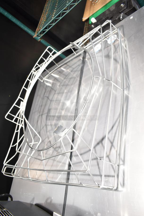 Alt text: Eight metal citrus juicer parts in wireframe design, stacked against a wall. Good condition.