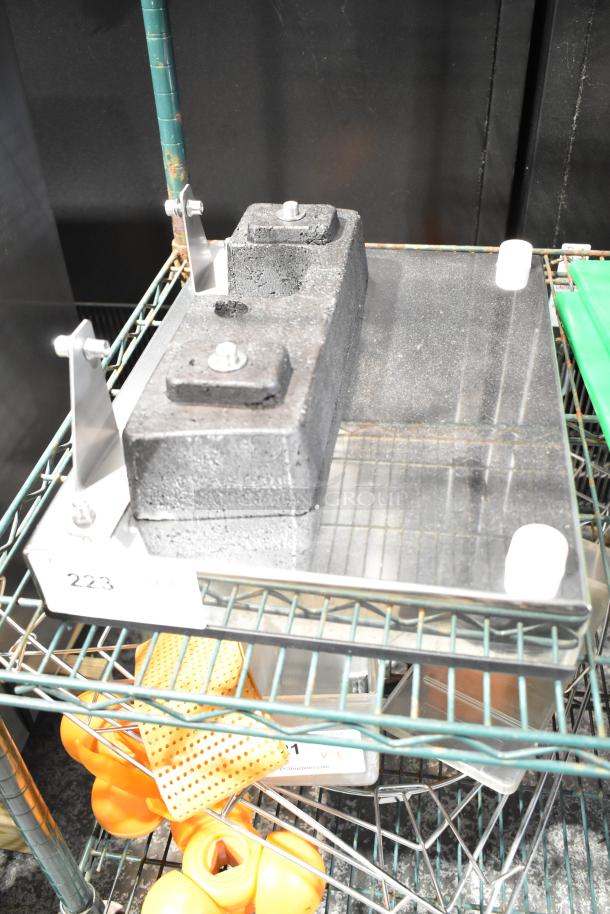 Metal panel with attached block, mounted on a shelf. Condition appears used. Visible label marked "223".