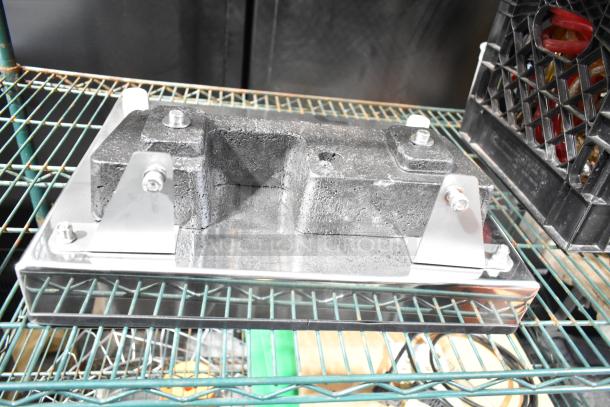 Industrial panel with metallic brackets and bolts, textured surface, mounted on a wire shelf. Good condition.