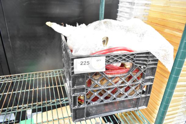 Crate containing various hoses and items, labeled "225 QTY ALL ONE MONEY!", on a metal shelf.