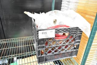 Crate containing various hoses and items, labeled "225 QTY ALL ONE MONEY!", on a metal shelf.