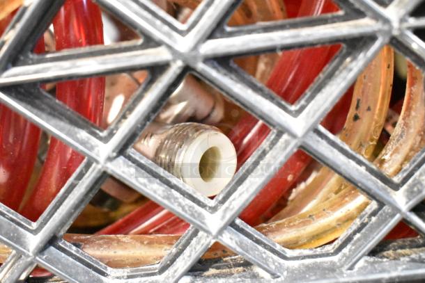 Lot of various items including red and yellow hoses inside a black crate, visible through lattice structure.