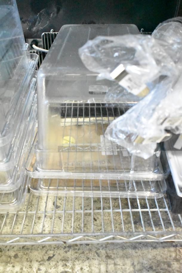 Stacked Cambro 12189CW135 Camwear® 18"x12"x9" clear food storage boxes on a shelf, new with slight blemishes.