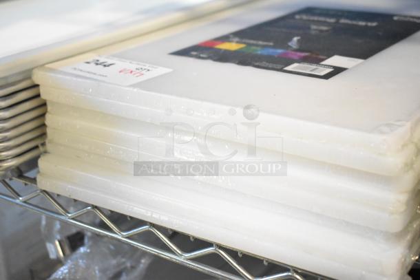 Stack of new Choice 18" x 12" x 1/2" white polyethylene cutting boards on a metal shelf, with labeled packaging.