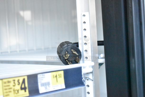 2019 True GDM-72F-HC Commercial 3 Door Freezer interior, metal shelves, price tags visible. Power plug shown on a shelf.