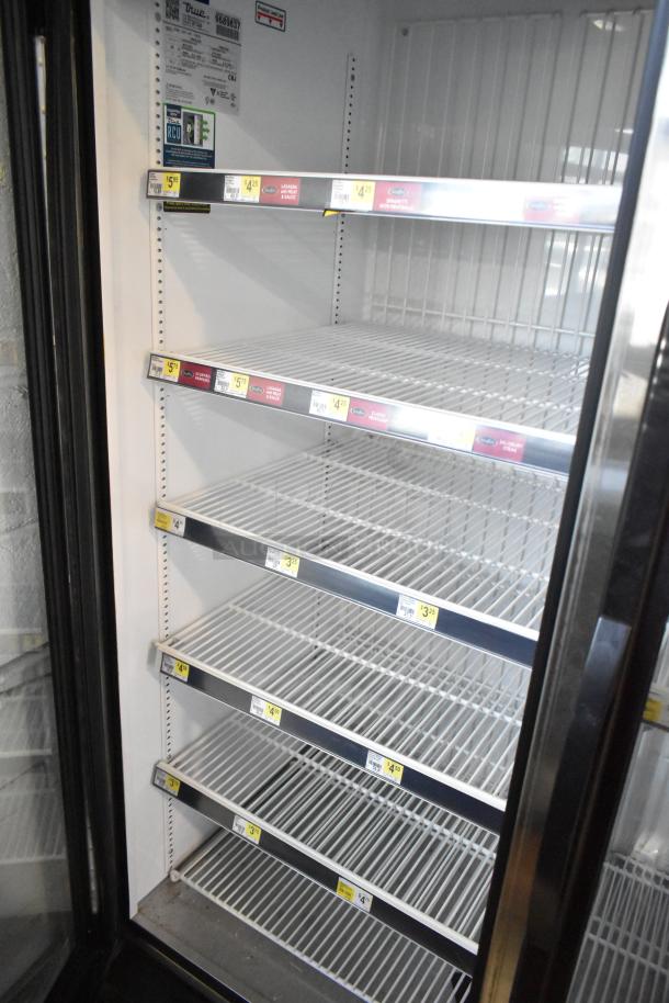2019 True GDM-72F-HC commercial 3-door reach-in freezer with shelves, model label visible.