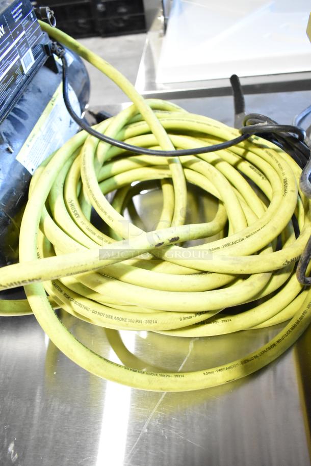 2016 Husky 0100211A air compressor with yellow hose. Visible labeling warns not to exceed 300 PSI. Good condition.