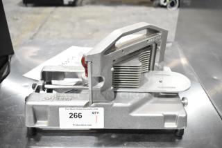 Tomato Saber countertop tomato slicer, metal construction, silver finish, visible blades, item tag "266" attached.