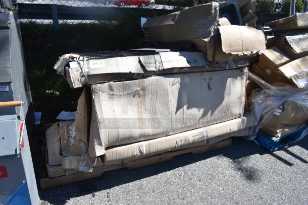 Damaged packaging containing new scratch and dent items including carts, equipment stand, and security cage on pallets.