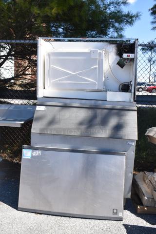 Manitowoc QY1305W commercial ice head on ice bin, 208-230V, 1 phase, stainless steel, outdoor setting, visible wear.