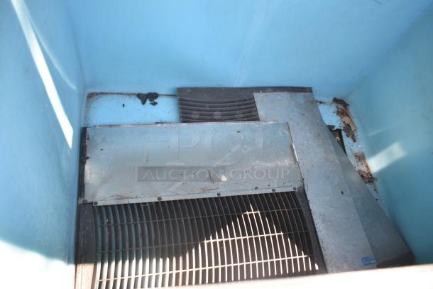 Manitowoc QY1305W Commercial Ice Head on Manitowoc Ice Bin. Visible signs of wear and debris in unit. 208-230V, 1 Phase.