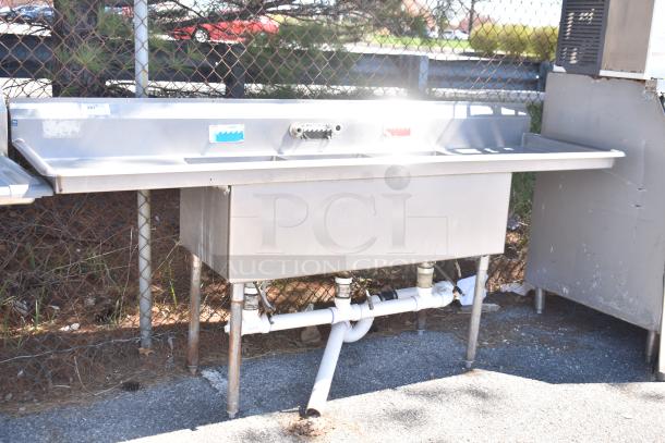 Duke Commercial 3 Bay Sink with dual drain boards, stainless steel, used condition, visible pipes, ideal for restaurant use.