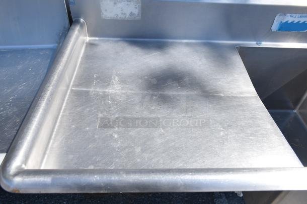 Duke Commercial 3 Bay Sink with dual drain boards, stainless steel, visible wear, ideal for restaurant use.