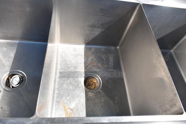 Duke Commercial 3 Bay Sink with dual drain boards, stainless steel, visible wear, integrated drains, durable for heavy use.