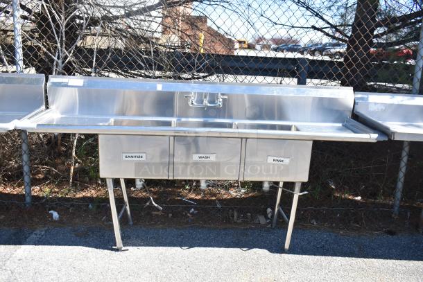 Commercial 3 bay stainless steel sink with dual drain boards, labeled "Sanitize," "Wash," and "Rinse," in good condition.