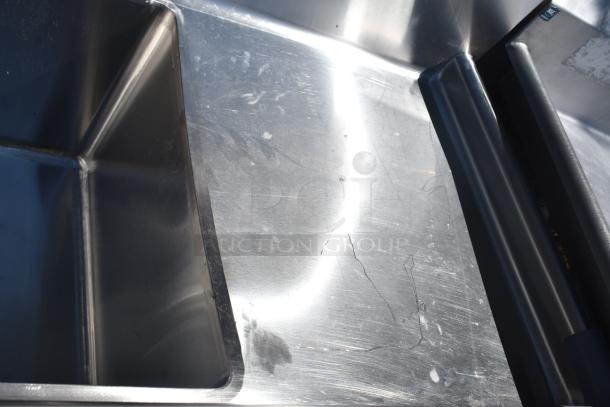 Commercial 3 Bay Sink with dual drain boards, stainless steel, visible signs of wear, ideal for restaurant use.