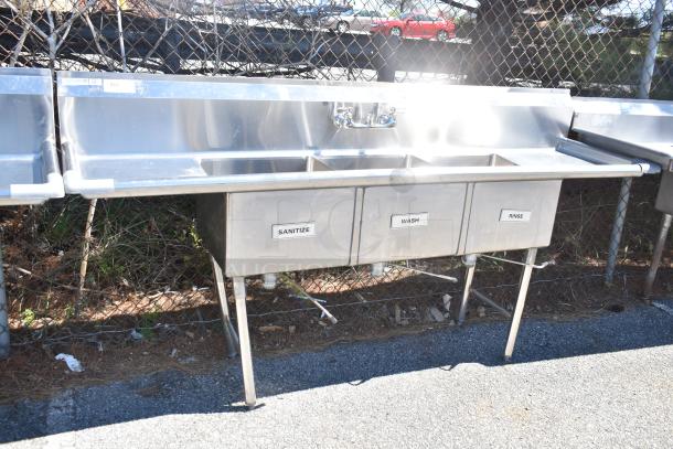 Commercial stainless steel 3 bay sink with dual drain boards, labeled sanitize, wash, rinse; durable condition.
