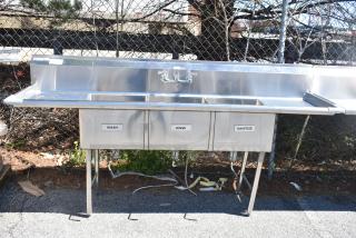 Commercial 3 bay sink with dual drain boards, featuring labeled "Wash," "Rinse," and "Sanitize" sections in stainless steel.