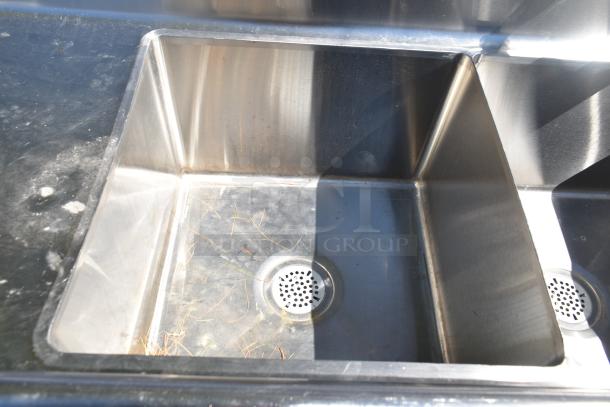 Commercial 3-bay stainless steel sink with dual drain boards, in used condition, visible wear inside bays.