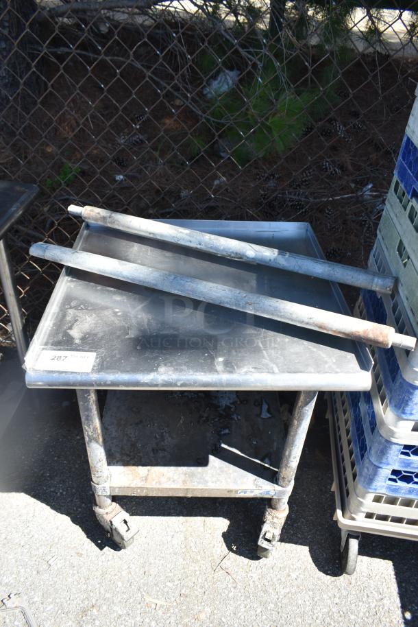 Commercial equipment stand with under shelf on casters, showing wear. Includes label "287". Durable, mobile storage solution.