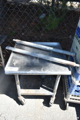 Commercial equipment stand with under shelf on casters, showing wear. Includes label "287". Durable, mobile storage solution.