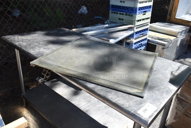 Industrial-grade commercial table with metal under shelf, showing signs of wear. Tag reads "288" indicating auction lot number.