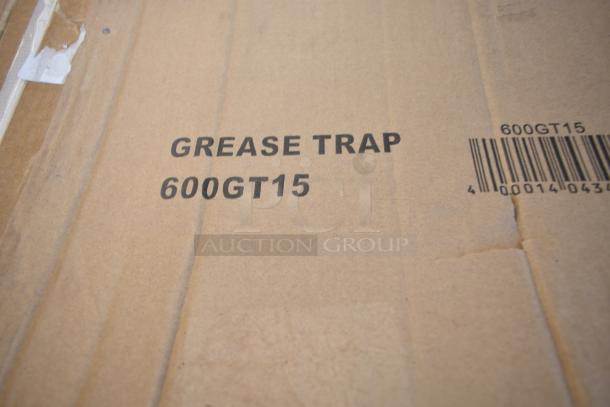 Cardboard box labeled "Grease Trap 600GT15" with visible barcode. Part of scratch and dent auction lot.