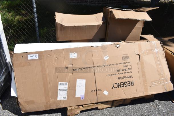 Boxes containing scratch and dent items, including Regency Work Table. Labels show model and handling instructions.