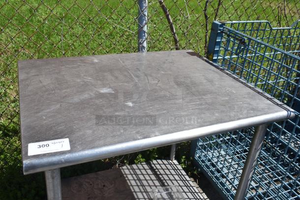 Commercial table with under shelf, on casters, metal surface, minor wear, includes auction tag 300.
