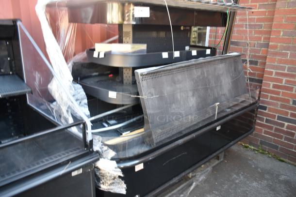 Commercial island style Grab N Go merchandiser, black, protection wrap partially removed, showing shelves and wiring, exterior use.