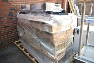 Pallet of 10 brand new scratch and dent items, including a dunnage rack and equipment stand, wrapped and stacked outdoors.