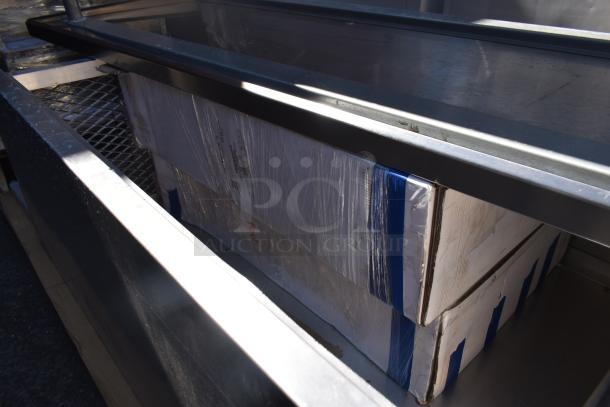 Four stacked wrapped items, possibly furniture parts, with visible metal framework. Items appear securely packaged for transport.