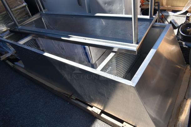 Industrial metal table and cabinet on pallet, featuring a stainless steel finish and wire mesh panels, in used condition.