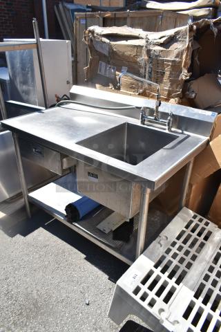Commercial counter with sink bay and drawer, stainless steel, fair condition, includes faucet and storage shelf underneath.