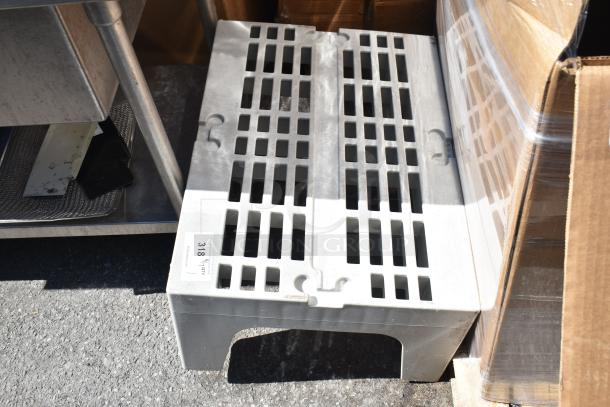 Gray poly dunnage rack with a slotted top for ventilation, used condition, labeled "318 41 QY Redistribution."