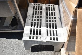 Gray poly dunnage rack with a slotted top for ventilation, used condition, labeled "318 41 QY Redistribution."
