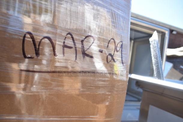 Packaged scratch and dent items, including stools, labeled "MAR-29," sealed in wrap, ready for auction.