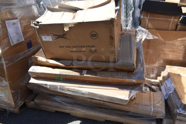 Stack of brand new scratch and dent items, including a tabletop and shelf, in unopened cardboard boxes. Tags and handling labels visible.