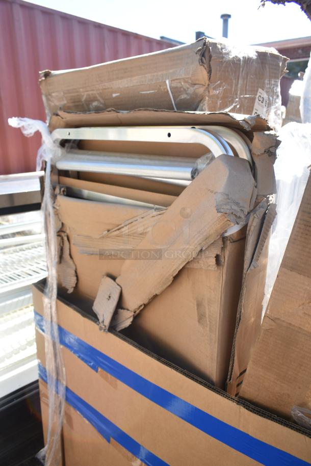 Cardboard box containing a new but scratched and dented ban rack and mop sink, partially unpacked, showing metal bars.