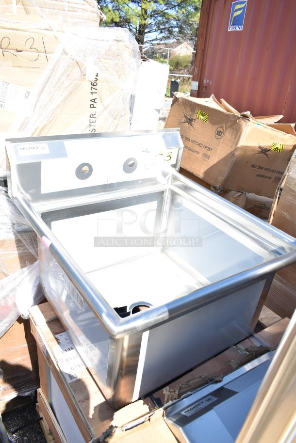Brand new Regency NSF mop sink, stainless steel, scratch and dent condition, on pallet with shipping boxes visible.