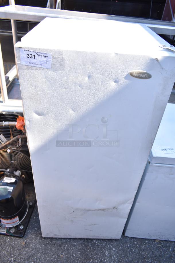 Wood's V07NAA single-door reach-in freezer, 115 volts, 1 phase. Shows signs of wear with dents and marks. Upper label included.