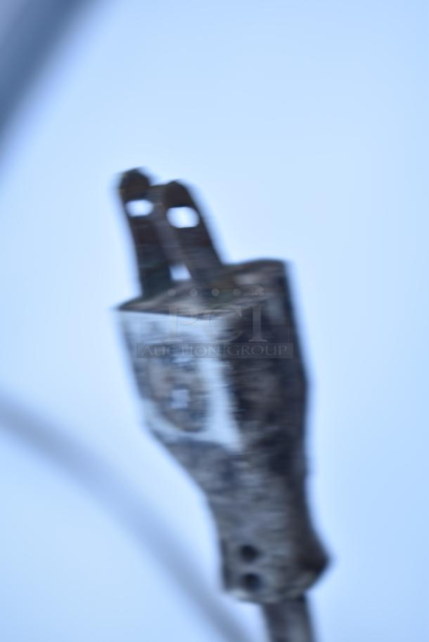 Blurry close-up of a worn electrical plug. No details visible about Wood's V07NAA Single Door Reach In Freezer.